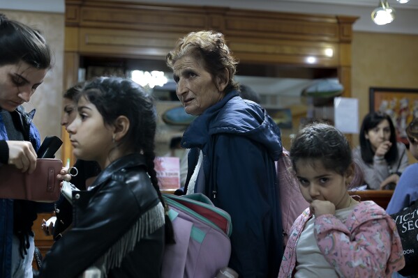 The first group of ethnic Armenians fleeing Nagorno-Karabakh wait to be temporarily checked into a hotel in Goris, in Armenia's Syunik region, Sunday, Sept. 24, 2023. (AP Photo/Vasily Krestyaninov)