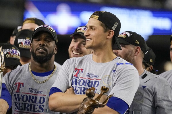 Texas Rangers shortstop Corey Seager stand by the trophy after Game 5 of the baseball World Series against the Arizona Diamondbacks Wednesday, Nov. 1, 2023, in Phoenix. The Rangers won 5-0 to win the series 4-1.(AP Photo/Brynn Anderson)