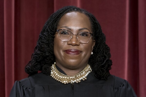 FILE - Associate Justice Ketanji Brown Jackson stands as she and members of the Supreme Court pose for a new group portrait following her addition in Washington, Oct. 7, 2022. (AP Photo/J. Scott Applewhite, File)