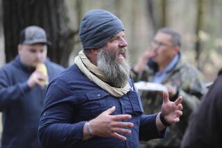 FILE - Daniel Banyai, the owner of Slate Ridge Vermont, speaks to supporters on April 17, 2021 in West Pawlet, Vt., during a Second Amendment Day Picnic at the unpermitted gun range and firearms training center. The Vermont Supreme Court on Friday, Jan. 14, 2022, upheld a lower court order that Banyai, the owner of an unpermitted his firearms training school that has drawn complaints about noise and intimidation from neighbors, must demolish any unpermitted buildings on the Pawlet property and pay more than $46,600 in fines. (AP Photo/Wilson Ring, File)