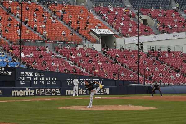 Fans wearing face masks to help protect against the spread of the new coronavirus watch the KBO league game between Doosan Bears and LG Twins in Seoul, South Korea, Sunday, July 27, 2020. Masked fans hopped, sang and shouted cheering slogans in baseball stadiums in South Korea on Sunday as authorities began bringing back spectators in professional sports games amid the coronavirus pandemic. (AP Photo/Ahn Young-joon)