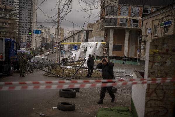 Police officers inspect area after an apparent Russian strike in Kyiv Ukraine, Thursday, Feb. 24, 2022. Russian President Vladimir Putin on Thursday announced a military operation in Ukraine and warned other countries that any attempt to interfere with the Russian action would lead to "consequences you have never seen." (AP Photo/Emilio Morenatti)