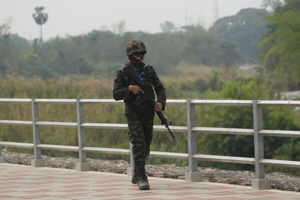 Thai military soldier keeps guard along the Moei river on the Thai side, under the 2nd Thai-Myanmar Friendship Bridge in Mae Sot in Thailand's Tak province on Friday, April 12, 2024. Thailand’s foreign minister says he has urged Myanmar’s military authorities not to violently respond to its army’s loss of an important border trading town to its opponents, and that so far it seemed to be exercising restraint. (AP Photo/Sakchai Lalit)