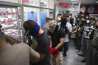 Four police officers wanted in connection with the murder of a suspect in their custody arrive at the Nakhon Sawan police station for interrogations in Nakhon Sawan province, Thailand, Wednesday, Aug. 25, 2021. The Four Thai police officers charged with with murder in connection with the deadly shakedown of a suspected drug dealer were arrested Wednesday after a video clip of the incident that went viral on social media caused a public furor. (AP Photo/Surat Sappakun)