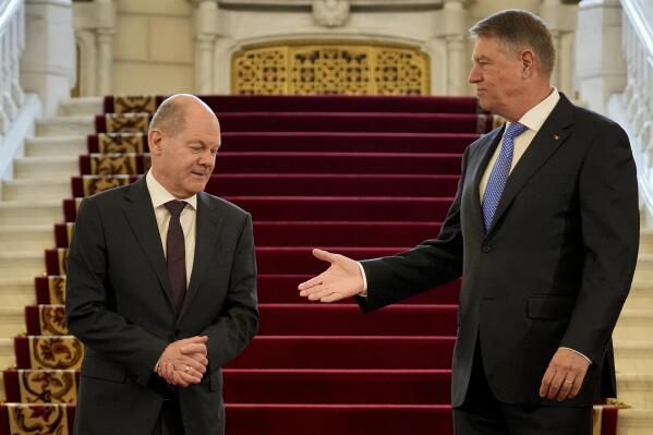 German Chancellor Olaf Scholz, left, prepares to shake hands with Romanian President Klaus Iohannis at the Cotroceni Presidential Palace in Bucharest, Romania, Monday, April 3, 2023. (AP Photo/Andreea Alexandru)