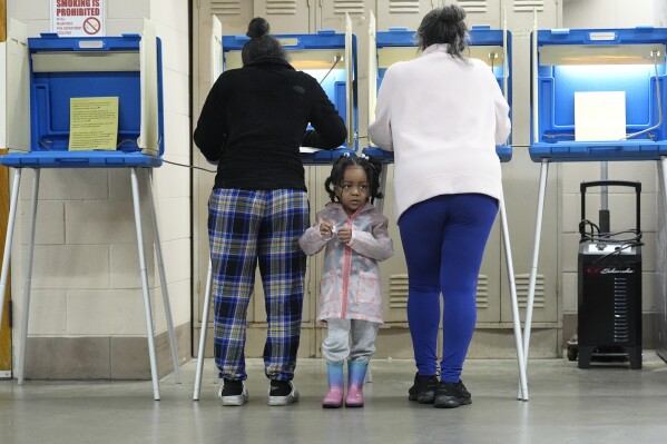 Three-year old- K-Lee waits as her mother Heather Ramsey votes during the Spring election Tuesday, April 2, 2024, in Milwaukee. (AP Photo/Morry Gash)