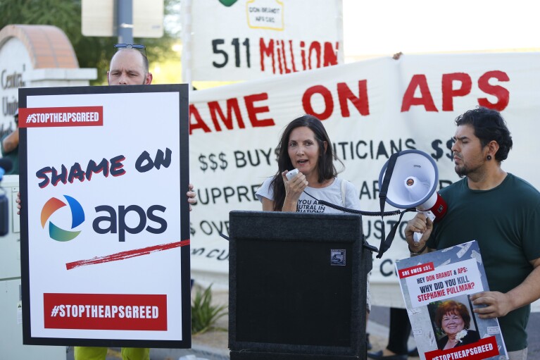 FILE - Stacey Champion speaks about the death of Stephanie Pullman outside of the Phoenix Art Museum where the Arizona Chamber of Commerce and Industry awards ceremony is celebrating Don Brandt, CEO of Arizona Public Service in Phoenix, Ariz., June 20, 2019. Pullman died in her home after her electricity had been shut off. (Patrick Breen/The Arizona Republic via AP, File)