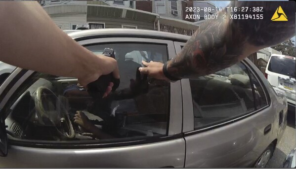 FILE - This screen grab taken from police body cam video shows Philadelphia Police Officer Mark Dial with his weapon drawn at Eddie Irizarry on Aug. 14, 2023 in Philadelphia. A judge has reinstated all charges, including a murder count, against the former officer who shot and killed the driver through a rolled-up car window — a confrontation police initially described as the officer shooting the driver after he lunged at him with a knife outside the car. Common Pleas Court Judge Lillian Ransom ruled Wednesday, Oct. 25, 2023 after a hearing that the facts of the case should be established at a trial. (Philadelphia Police Department via AP, File)