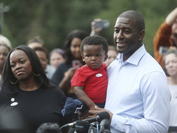 
              Florida Gubernatorial Democratic candidate Mayor Andrew Gillum takes questions from the press while his wife R. Jai Gillum, and children look on after casting their ballots at the Go...