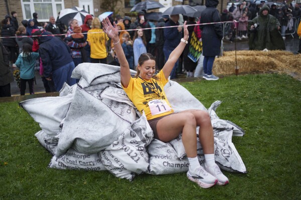 Winner Ferne Gardener reacts after racing with a 20kg sack of coal for over 1km during the World Coal Carrying Championships in Ossett, West Yorkshire, England, Monday, April 21, 2025. (AP Photo/Jon Super)