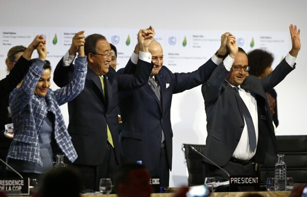 FILE - French President François Hollande, right, French Foreign Minister and COP21 President Laurent Fabius, second right, UN climate chief Christiana Figueres, left, and UN Secretary-General Ban Ki-moon raise their hands in celebration after the final.  Conference at the United Nations Conference on Climate Change, COP21, in Le Bourget, north of Paris, on December 12, 2015.  (AP Photo/Francois Mori, File)