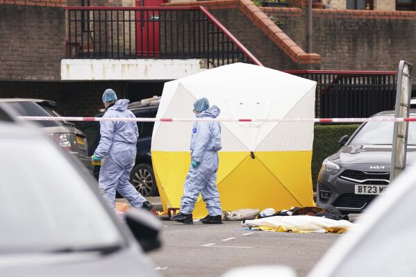 Police forensic officers at the scene near Bywater Place in Surrey Quays, south east London, where a man has died after being shot by armed police responding to calls for help in the early hours of this morning, Tuesday, Jan. 30, 2024. London police say they fatally shot a man reportedly armed with a crossbow who broke into a home and threatened the occupants. (Lucy North/PA via AP)