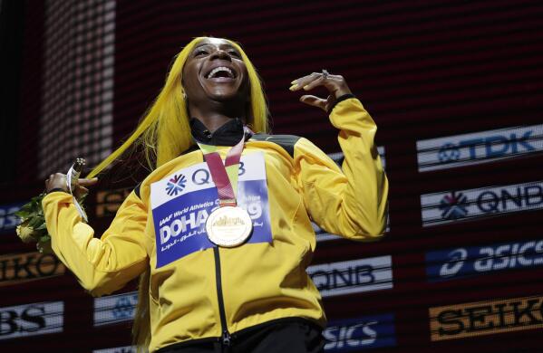 FILE - In this file photo dated Monday, Sept. 30, 2019, Shelly-Ann Fraser-Pryce of Jamaica, gold medalist in the women's 100 meters, reacts during the medal ceremony at the World Athletics Championships in Doha, Qatar.  Moving from their sports field to the living room, many athletes around the world are doing their bit to boost public health during the coronavirus pandemic lockdown, and one of them is two-time 100-meter champion Shelly-Ann Fraser-Pryce of Jamaica, who is reading her children's book. (AP Photo/Nariman El-Mofty, FILE)