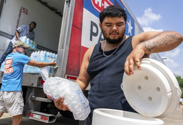 FILE - Daniel Valdez places a fresh bag of ice in a cooler he brought on foot from his apartment as volunteers at the Memorial Assistance Ministries distribute water and ice, Saturday, May 18, 2024, in Houston. Extreme heat in Mexico, Central America and parts of the U.S. South has left millions of people sweltering, strained energy grids and resulted in iconic Howler monkeys in Mexico dropping dead from trees. (Jason Fochtman/Houston Chronicle via AP, File)