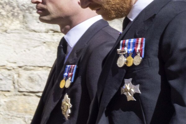 Prince William, left and Prince Harry follow the Land Rover Defender carrying the Duke of Edinburgh's coffin ahead of his funeral at Windsor Castle, in Windsor, England, Saturday April 17, 2021. Prince Philip died April 9 at the age of 99 after 73 years of marriage to Britain's Queen Elizabeth II. (Ian Vogler/Pool via AP)