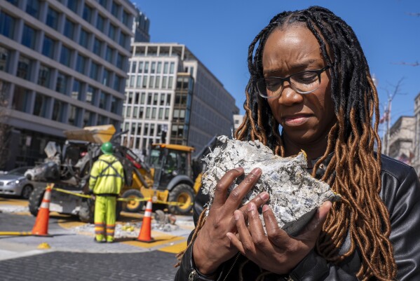 Tears roll down the face of Starlette Thomas, of Bowie, Md., as she holds a chunk of pavement from the Black Lives Matter mural, Monday, March 10, 2025, as the mural begins to be demolished in Washington. "I needed to be here to bear witness," says Thomas, who was present at the 2020 George Floyd protests. "For me the Black Lives Matter sign etched in stone was a declaration of somebodyness and to watch it be undone in this way was very hurtful. To walk away with a piece of that, it means it's not gone. It's more than brick and mortar." (AP Photo/Jacquelyn Martin)