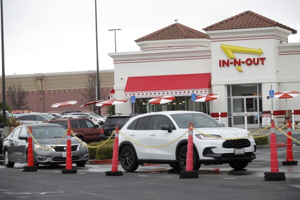 Customers line up at the In-N-Out drive-thru off Hegenberger Road in Oakland, Calif., on Monday, Jan. 22, 2024. In-N-Out will close its only restaurant in Oakland because of a wave of car break-ins, property damage, theft and armed robberies targeting customers and employees alike, the company announced. The burger joint in a busy corridor near the Oakland International Airport will close on March 24, 2024. (Jane Tyska/Bay Area News Group via AP)