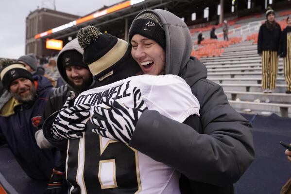 Purdue quarterback Aidan O'Connell is hugged by his wife Jael after Purdue defeated Illinois 31-24 in an NCAA college football game Saturday, Nov. 12, 2022, in Champaign, Ill. (AP Photo/Charles Rex Arbogast)