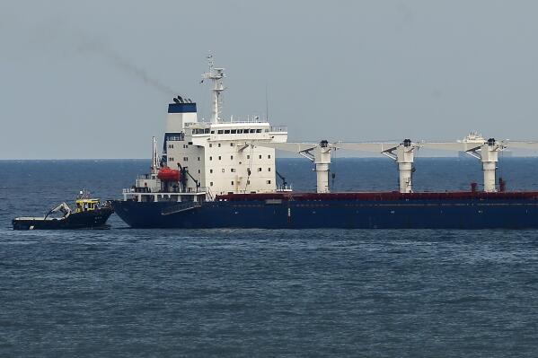 FILE - A boat with Russian, Ukrainian, Turkish and U.N. officials heads to the Sierra Leone-flagged cargo ship Razoni, to check if the grain shipment is in accordance with a crucial agreement signed last month by Moscow and Kyiv, at an inspection area in the Black Sea off the coast of Istanbul, Turkey, on Aug. 3, 2022. Inspections of ships carrying Ukrainian grain and other food exports have slowed to half their peak rate under a U.N.-brokered wartime agreement, creating backlogs in vessels meant to carry supplies to developing nations where people are going hungry, United Nations and Ukrainian officials say. (AP Photo/Emrah Gurel, File)