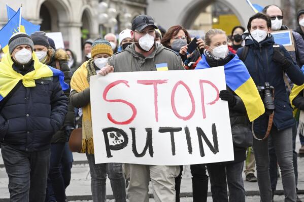 Protesters hold a placard reading "Stop Putin" during a demonstration at Odeonsplatz against Russia's attack on Ukraine, Munich, Germany, Saturday, Feb. 26, 2022.(Tobias Hase/dpa via AP)