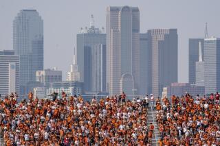 FILE - The Dallas skyline rises behind the Cotton Bowl stands as Texas fans watch during the first half of an NCAA college football game against Oklahoma at the Cotton Bowl, Saturday, Oct. 8, 2022, in Dallas. U.S. metropolitan areas increased their populations by almost half a percent last year in another sign that flight from urban areas during the first year of the pandemic either slowed down or reversed in its second year as people moved to Sunbelt metros in Texas and Florida by the tens of thousands. (AP Photo/Jeffrey McWhorter, File)