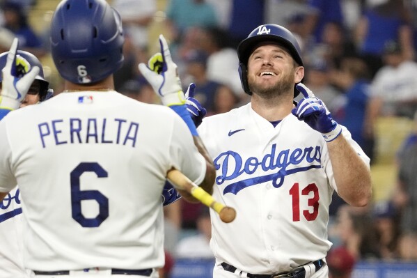 Los Angeles Dodgers' Max Muncy, right, is congratulated by David Peralta after hitting a two-run home run during the first inning of a baseball game against the Arizona Diamondbacks Monday, Aug. 28, 2023, in Los Angeles. (AP Photo/Mark J. Terrill)