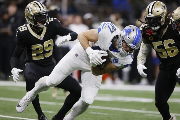 Detroit Lions tight end Sam LaPorta (87) catches a pass as New Orleans Saints cornerback Paulson Adebo (29) and linebacker Demario Davis (56) defend during the second half of an NFL football game, Sunday, Dec. 3, 2023, in New Orleans. (AP Photo/Butch Dill)