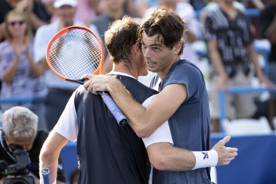 Taylor Fritz, right, embraces Andy Murray after their match during the DC Open tennis tournament Friday, Aug. 4, 2023, in Washington. (Minh Connors/The Washington Post via AP)