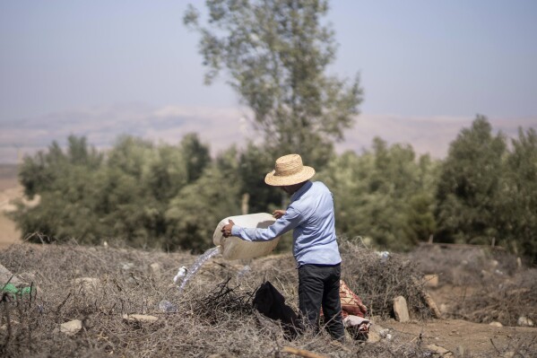 Moussa Bouissirfane, a man who lost his parents and daughter in the earthquake, looks after their graves, in the village of Tafeghaghte, near Marrakech, Morocco, Monday, Sept. 11, 2023. (AP Photo/Mosa'ab Elshamy)