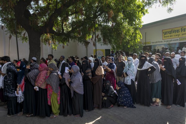 People stand in a queue to vote during the second round of voting in the six-week-long national election in Nahal village near Meerut, in Uttar Pradesh, India, Friday, April 26, 2024. (AP Photo/Altaf Qadri)