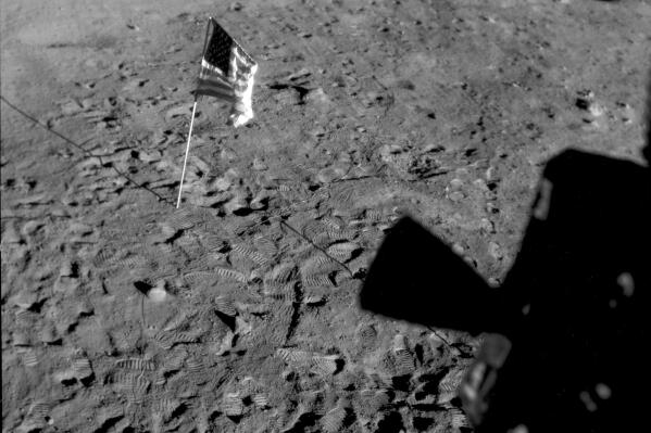FILE - This July 21, 1969 photo made available by NASA shows a U.S. flag planted at Tranquility Base on the surface of the moon, and a silhouette of a thruster at right, seen from a window in the Lunar Module. On Tuesday, Nov. 9, 2021, NASA announced it is delaying putting astronauts back on the moon until 2025 at the earliest. (NASA via AP, File)