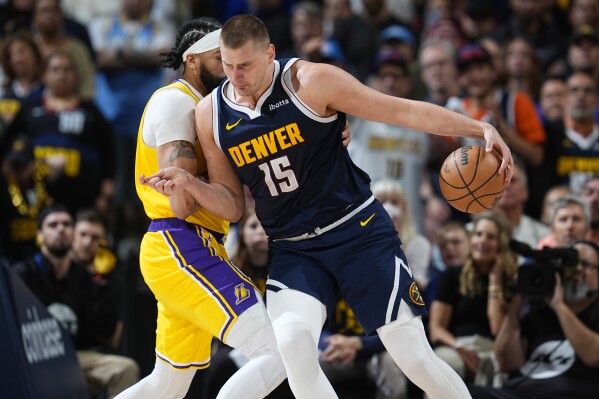Denver Nuggets center Nikola Jokic (15) drives past Los Angeles Lakers forward Anthony Davis in the second half of Game 5 of an NBA basketball first-round playoff series Monday, April 29, 2024, in Denver. (AP Photo/David Zalubowski)
