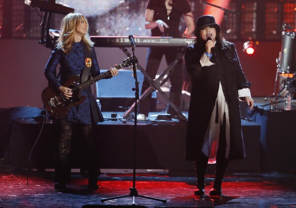 FILE - Nancy Wilson, left, and Ann Wilson, right, of the band Heart perform as Heart is inducted into the Rock and Roll Hall of Fame during the Rock and Roll Hall of Fame Induction Ceremony at the Nokia Theatre on Thursday, April 18, 2013 in Los Angeles. Heart — the pioneering band that melds Nancy Wilson’s shredding guitar with her sister Ann’s powerhouse vocals — is hitting the road this spring for a world tour that Nancy Wilson describes as “the full-on rocker size.” (Photo by Danny Moloshok/Invision/AP, File)