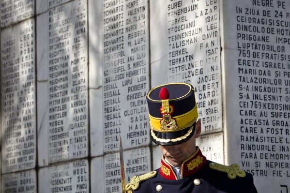 A honor guard soldier stands during a ceremony  at a Jewish cemetery in Bucharest, Romania, Friday, Feb. 24, 2012, next to a monument bearing the names of Jews killed 70 years ago when the SS Struma, the ship they were on as refugees on the way to Palestine, was sunk by a Soviet torpedo in the Black Sea leading to the death of all but one of the 779 people on board. (APPhoto/Vadim Ghirda)