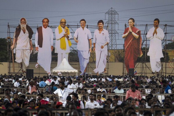 Large cutouts representing Dravida Munnetra Kazhagam and Indian National Congress leaders, tower over supporters during an election campaign rally, on the outskirts of southern Chennai, India, April 15, 2024.  (AP Photo/Altaf Qadri)