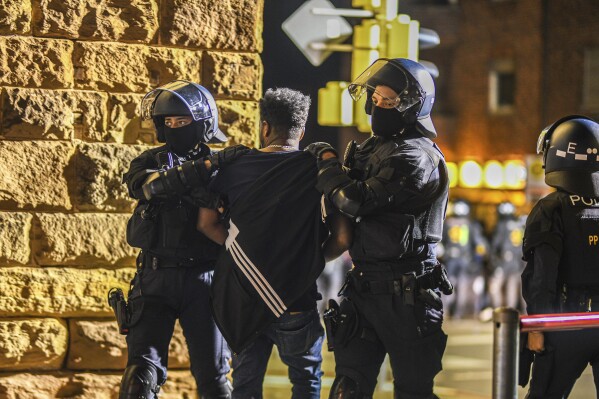 A man is taken away by police officers in Stuttgart, Baden-Württemberg, Germany, on Saturday, Sept. 16, 2023, after clashes at a gathering of Eritrean groups. (Jason Tschepljakow/dpa via AP)