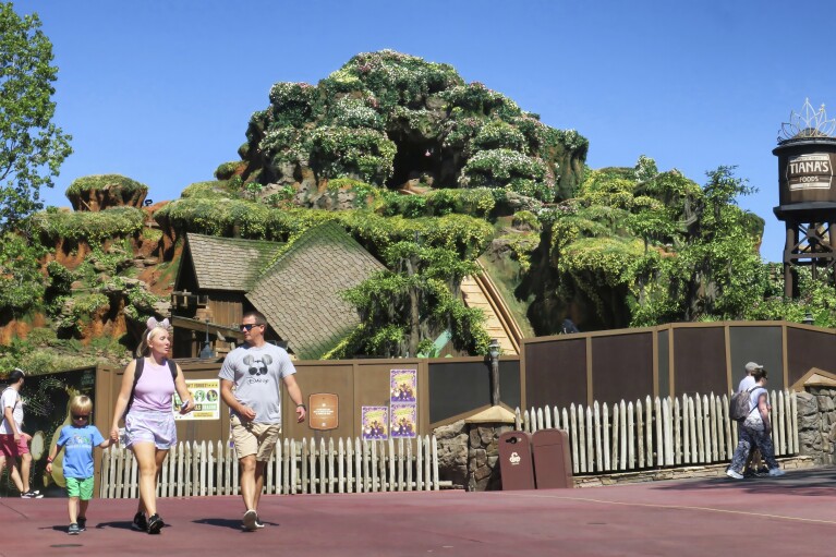 Guests pass by Tiana's Bayou Adventure, the reimagined former Splash Mountain ride in the Magic Kingdom at Walt Disney World, as work continues Thursday, May 23, 2024, ahead of its planned June 28 opening in Bay Lake, Fla. The attraction's new theme is based on the Disney film 