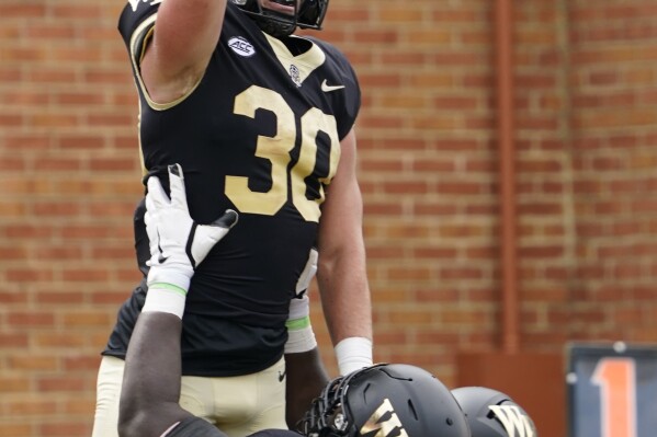 Wake Forest running back Tate Carney (30) celebrates his touchdown run against Vanderbilt with Nick Sharpe (70) during the first half of an NCAA college football game in Winston-Salem, N.C., Saturday, Sept. 9, 2023. (AP Photo/Chuck Burton)