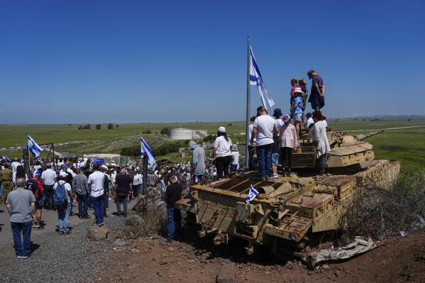 Israelis stand still to observe two minutes of silence as air raid sirens sound to mark Israel's annual Memorial Day for fallen soldiers, in Tel Saki memorial site for 1973's Mideast war in the Israeli-controlled Golan Heights, on the border with Syria, Tuesday, April 25, 2023. (AP Photo/Ariel Schalit)