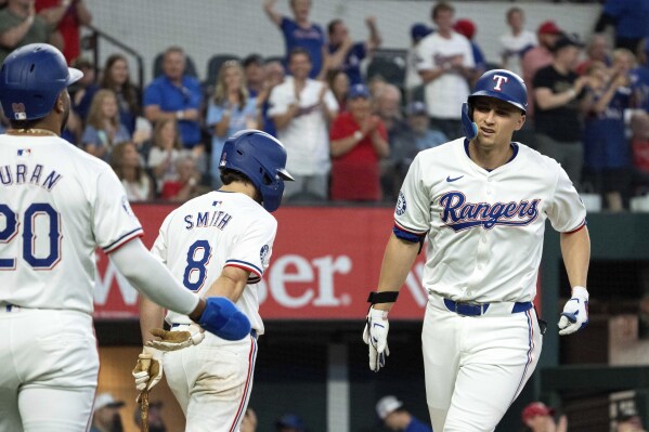 Texas Rangers' Corey Seager is congratulated by Ezequiel Duran (20) after hitting a two run home run that scored Duran off of Arizona Diamondbacks starting pitcher Ryne Nelson during the fifth inning of a baseball game Wednesday, May 29, 2024, in Arlington, Texas. The home run was Seager's eighth in as many games. (AP Photo/Jeffrey McWhorter)