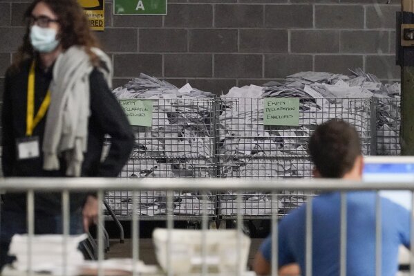 Bins of the empty envelopes from ballots are stored along a wall as election office workers process ballots while counting continues from the general election at the Allegheny County elections returns warehouse in Pittsburgh, Friday, Nov. 6, 2020. (AP Photo/Gene J. Puskar)