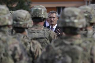 FILE - NATO Secretary General Jens Stoltenberg talks to US army soldiers while visiting Prague, Czech Republic, Wednesday, Sept. 9, 2015. On Wednesday April 26, 2023, the Czech government agreed to sign a defense military treaty with the United States. The treaty will set a legal framework for possible deployment of U.S. troops on Czech territory and their cooperation with the Czech armed forces. (AP Photo/Petr David Josek, File)
