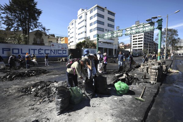 Volunteers help to clean up streets in the aftermath of violent protests against the government, in Quito, Ecuador, Monday, Oct. 14, 2019. Ecuador celebrated a deal President Lenín Moreno and indigenous leaders struck late Sunday to cancel a disputed austerity package and end nearly two weeks of protests that have paralyzed the economy and left seven dead. (AP Photo/Fernando Vergara)