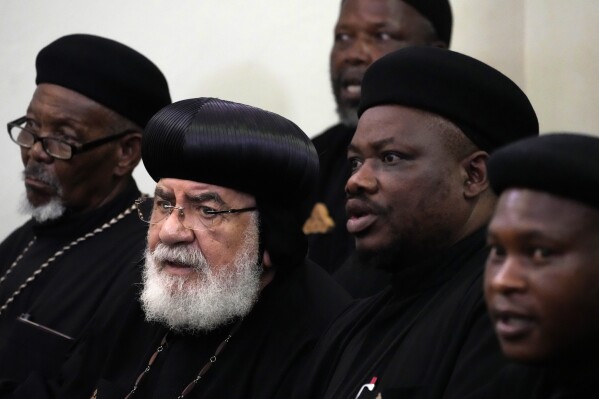 Members of the Saint Mark the Apostle and Saint Samuel the Confessor Monastery sit at the magistrate court in Cullinan, a town east of Pretoria, South Africa, Thursday, March 14, 2024. Two suspects appeared at the court for the murder of three Egyptian monks belonging to the Coptic Orthodox Church at a monastery in South Africa. (AP Photo/Themba Hadebe)