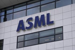 FILE - the logo of ASML, a leading maker of semiconductor production equipment, hangs on the head office in Veldhoven, Netherlands, Monday, Jan. 30, 2023. The Dutch government announced Tuesday that it is planning on imposing additional restrictions on the export of machines that make advanced processor chips, joining a U.S. initiative that aims at restricting China's access to materials used to make such chips. Dutch Minister for Foreign Trade and Development Cooperation Liesje Schreinemacher sent a letter to lawmakers outlining the proposed limitations, which come in addition to existing export controls on semiconductor technology. (AP Photo/Peter Dejong, File)