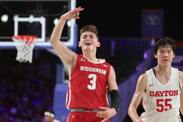 This photo provided by Bahamas Visual Services shows Wisconsin guard Connor Essegian reacting next to Dayton's Mike Sharavjamts (55) during an NCAA college basketball game at the Battle 4 Atlantis at Paradise Island, Bahamas, Wednesday, Nov. 23, 2022. . (Tim Aylen/Bahamas Visual Services via AP)