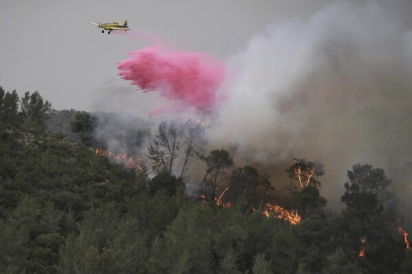 A plane uses a fire retardant to extinguish a fire burning in a forest near Jerusalem, Wednesday, April 30, 2025. (AP Photo/Mahmoud Illean)