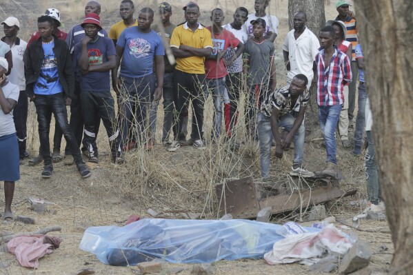 The body of a dead miner lies on the ground wrapped in a plastic sheet after been retrieved from a collapsed mine shaft in Chegutu, about 100 kilometers (60 miles) west of the capital Harare, Saturday, Sept. 30 2023. Several people have died from the collapse of a gold mine in Zimbabwe, according to state media reports. (AP Photo)