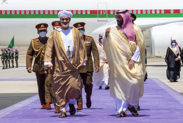 In this photo released by Saudi Royal Palace, Saudi Crown Prince Mohammed bin Salman, right, receives Omani Sultan Haitham bin Tariq, at Neom Bay Airport, in the Tabuk Province of northwestern Saudi Arabia, Sunday, July 11, 2021. (Bandar Aljaloud/Saudi Royal Palace via AP)