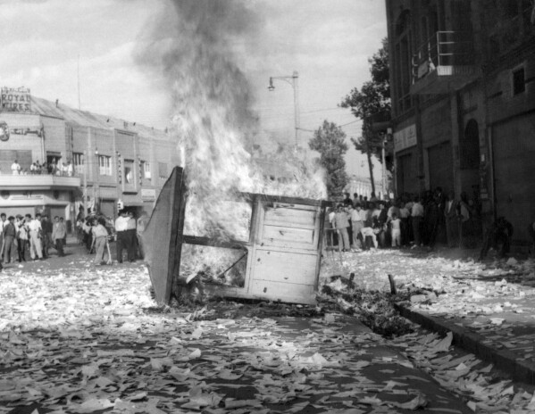 FILE - A Communist newspaper kiosk burned by pro-shah demonstrators after the coup d'etat which ousted Prime Minister Mohammad Mossadegh, in Tehran, Iran on Aug. 19, 1953. In August 1953, a CIA-backed coup toppled Iran's prime minister, cementing the rule of Shah Mohammad Reza Pahlavi for over 25 years before the 1979 Islamic Revolution. (AP Photo, File)